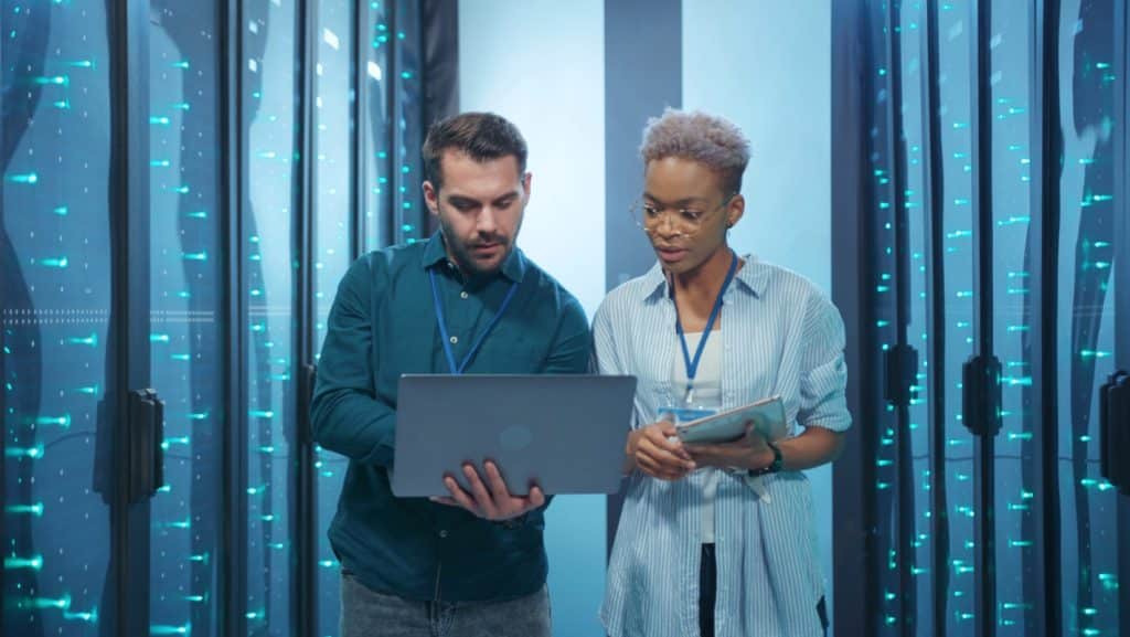 a man and woman looking at a laptop